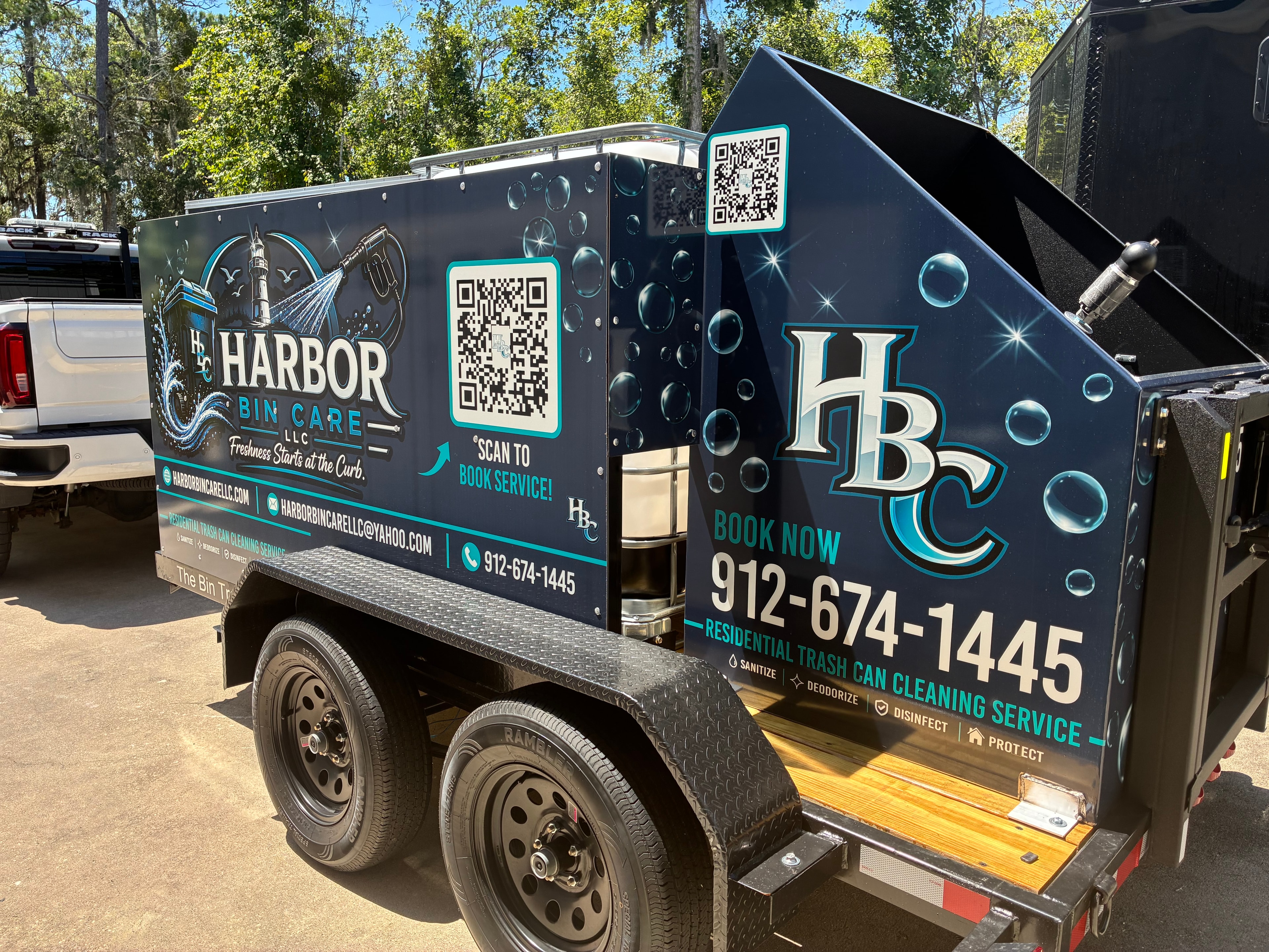 Harbor Bin Care LLC trailer showing full side wrap with HBC logo, QR code, Book Now and 912-674-1445